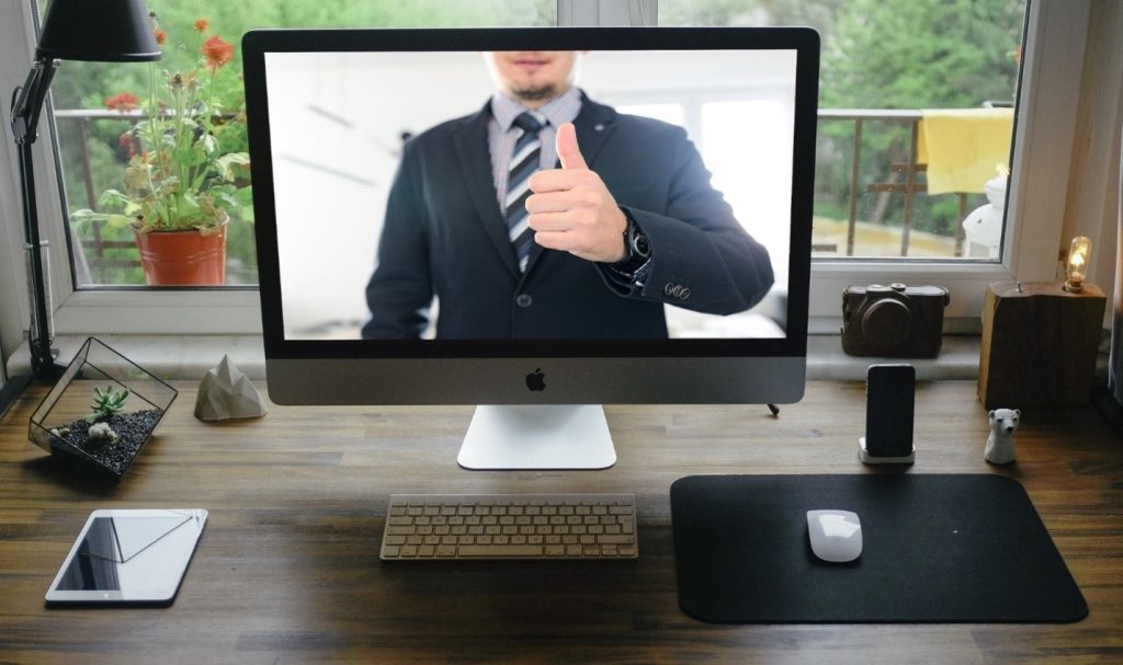 A man on screen gives the thumbs-up signal to start the virtual business networking event